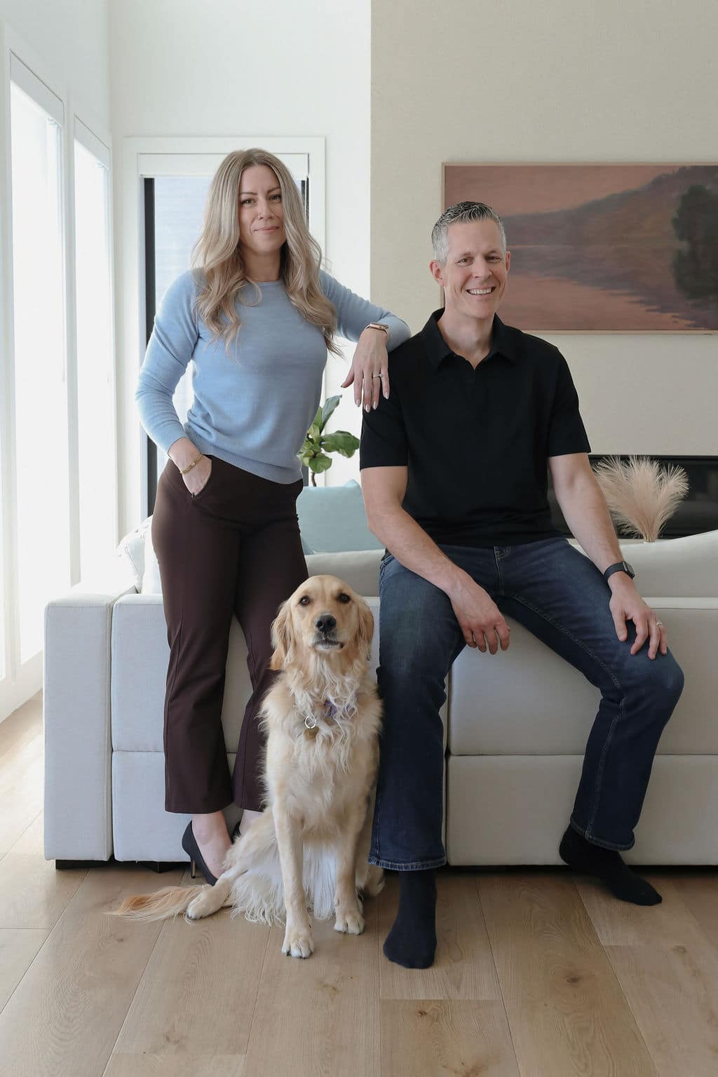 Robb Engen and Lindsay Engen with dog sitting on couch at home